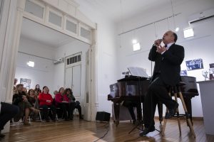 El artista cantando en salas, mientras el público disfruta
